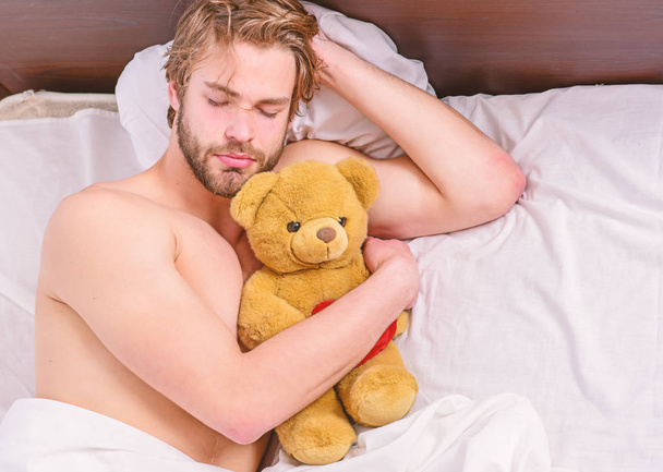 Un jeune homme se réveille dans son lit et étire les bras. Pieds d'homme dormant dans un lit confortable. Réveille-toi
. - Photo, image