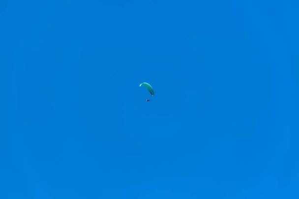 Перегляд парапланетянина, що висить у повітрі, блакитне небо як фон
 - Фото, зображення