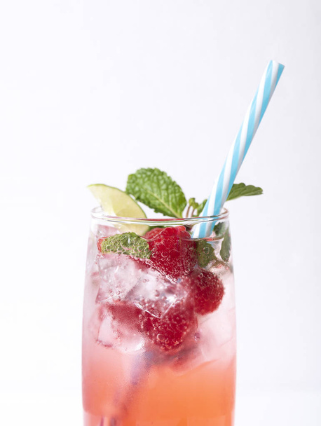 Iced Red Raspberry Punch cocktail met limoen in glas op wit  - Foto, afbeelding