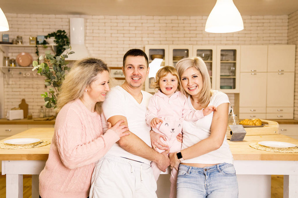 beautiful family dad mom and daughter have fun in the kitchen in a bright apartment - Foto, Imagem