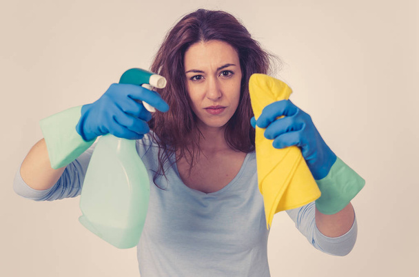 クリーニングスプレーと布のクリーニング感にイライラして怒りと動揺女性。汚れは出ない青い背景に隔離された国内業務や清掃用品広告画像. - 写真・画像