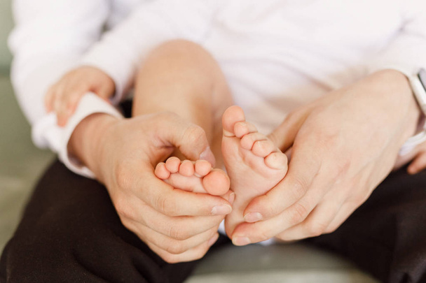 bebek ayakları tutan baba ellerin kırpılmış atış - Fotoğraf, Görsel