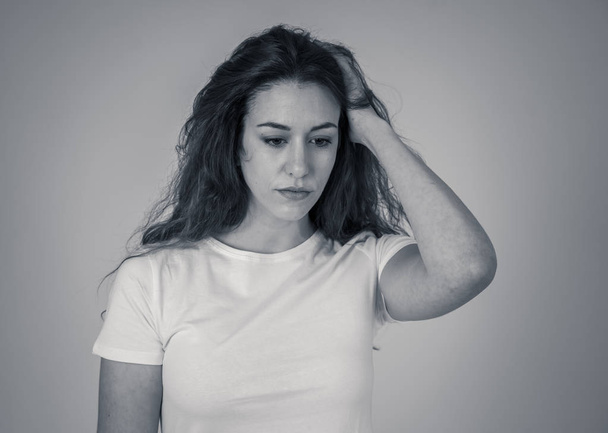 Portrait of young sad woman looking worried in emotional pain. Feeling sorrow and suffering from depression. Isolated in neutral background. In mental health and facial expressions and emotions. - Fotoğraf, Görsel
