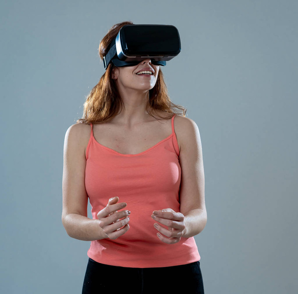 Amazed attractive woman using VR headset glasses touching and interacting with virtual reality world. Feeling excited exploring and having fun in 360 VR simulation. Innovation and new technology. - Photo, image