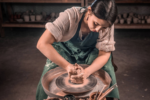Stylowy mistrz rzemieślniczy do produkcji garnka ceramicznego na kole garncarniczym. Ręcznie. - Zdjęcie, obraz
