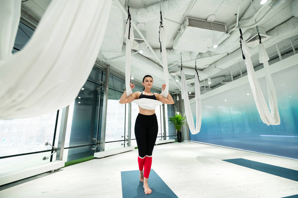 Woman standing on mat before practicing aerial yoga - Foto, imagen