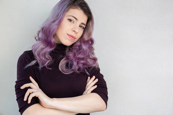 巻き毛の紫色の髪とナチュラルメイクのポーズを持つ素敵な若い女性 - 写真・画像