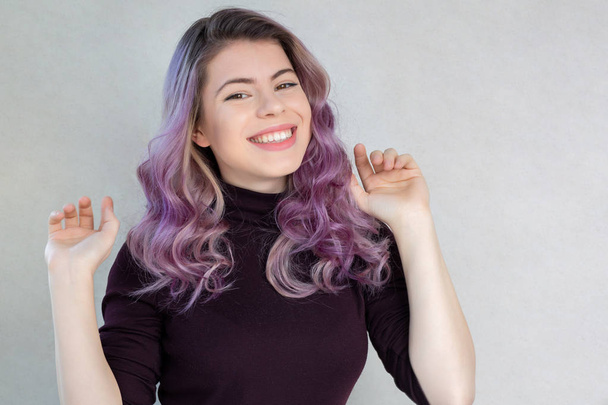 Pleased young woman with wavy purple hair and natural makeup. Sp - Photo, Image
