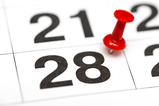 Pin en la fecha número 28. El vigésimo octavo día del mes está marcado con una chincheta roja. Pin en el calendario
 - Foto, Imagen