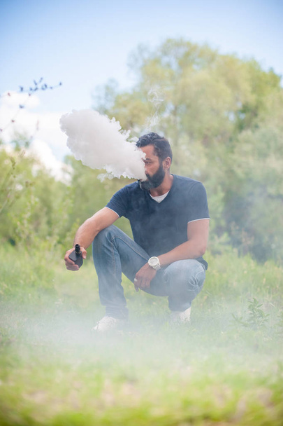 Stylish man exhales cloud of smoke. Handsome man. - Photo, Image