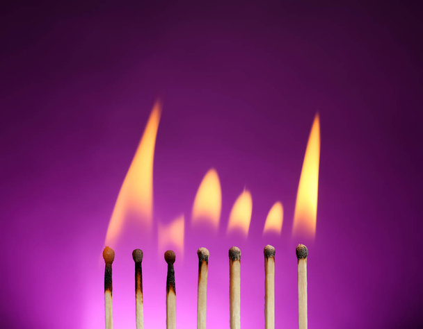Line of burning matches on color background - Valokuva, kuva