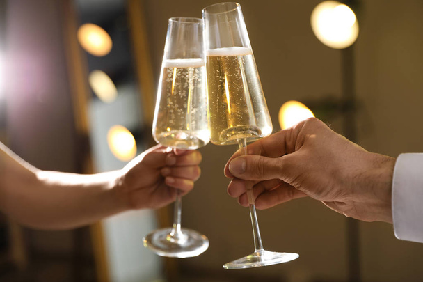 Man and woman clinking glasses of champagne on blurred background, closeup - Foto, immagini