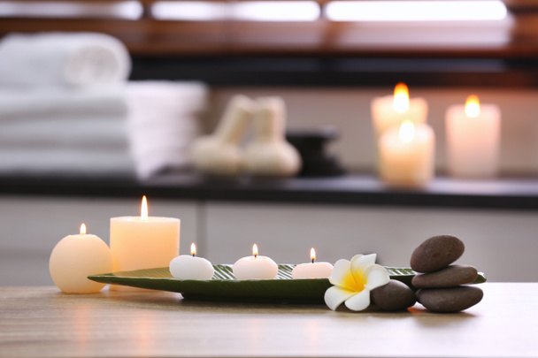 Composition with candles and stones on table in spa salon. Space for text - Photo, image