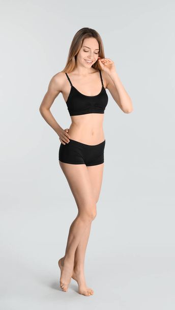 Young slim woman on light background. Perfect body - Foto, immagini
