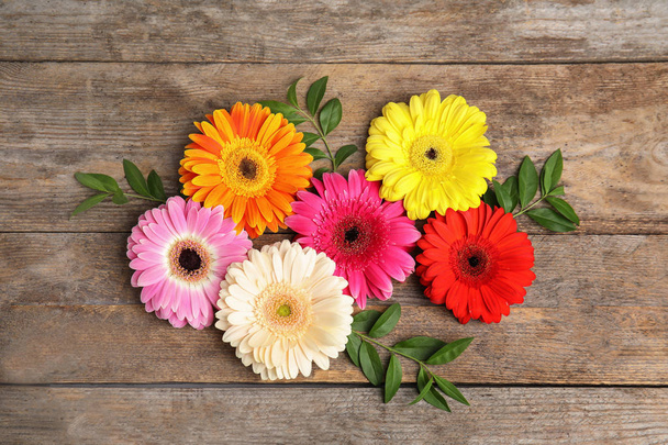 Flat lay composition with beautiful bright gerbera flowers on wooden background, top view - Φωτογραφία, εικόνα