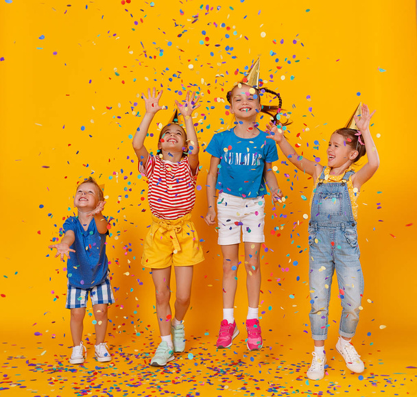 happy children on holidays  jumping in multicolored confetti on  - Foto, immagini