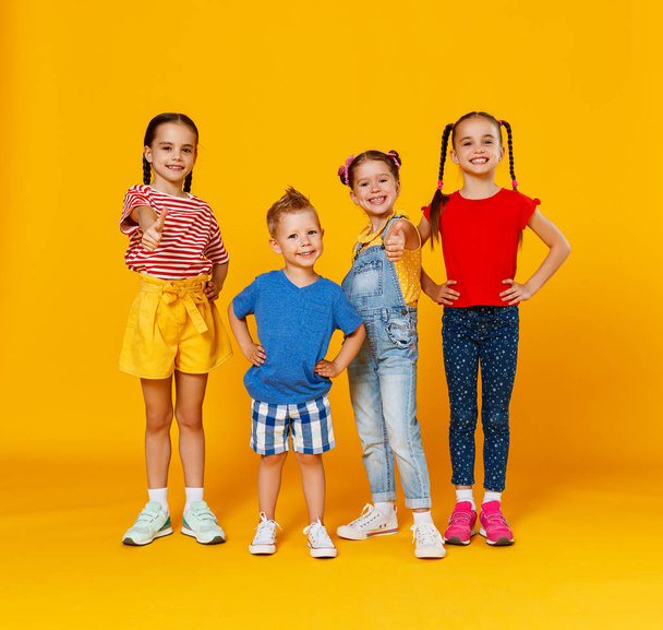 группа веселых счастливых детей на цветной желтой спине
 - Фото, изображение