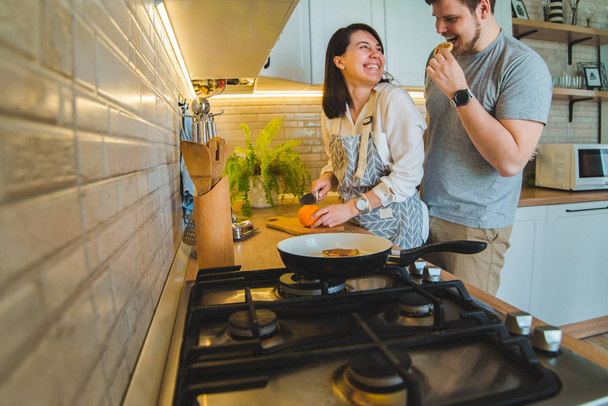 mooie paar knuffelen op de keuken tijdens het koken ontbijt - Foto, afbeelding
