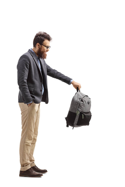 Full length shot of a bearded man holding a backpack isolated on white background - Foto, imagen