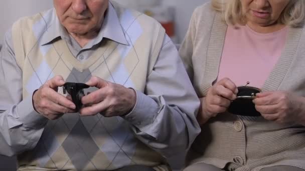 Miserable old couple showing empty purses, high tariffs, social problems - Filmati, video