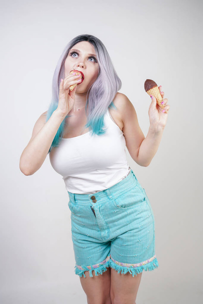 pretty caucasian blonde short hair girl eating tasty ice-cream with waffle cone and chocolate on white studio background - Photo, image