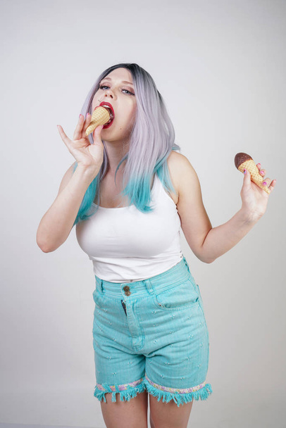 довольно кавказская блондинка короткие волосы девушка ест вкусное мороженое с вафельным конусом и шоколадом на белом фоне студии
 - Фото, изображение