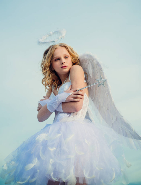 Child with angelic character. Little angel girl against sunny sky. A child in the clothes of an angel on sky background - Valentine concept. The God of Love. - Photo, image