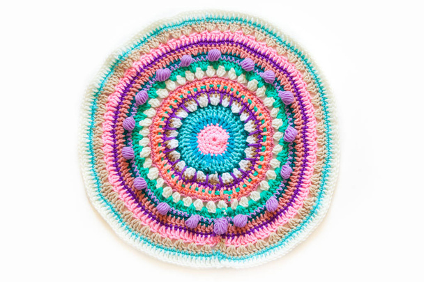 Round mandala crocheted from colored yarn. White background. - Foto, Bild
