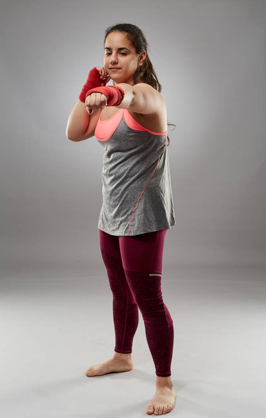 Young kickboxing female fighter in hand wraps, barefoot - Valokuva, kuva