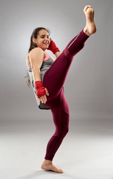 Young kickboxing female fighter in hand wraps, barefoot - Foto, imagen