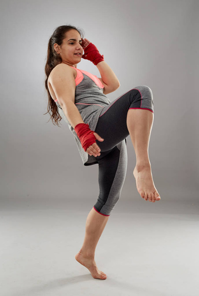 Young kickboxing female fighter in hand wraps, barefoot - Valokuva, kuva