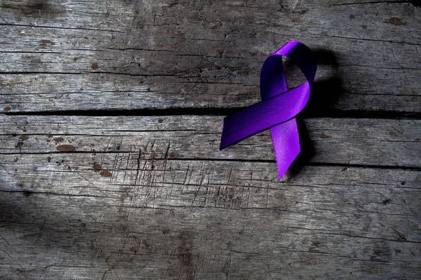 een paars lint voor de bewustwording van het onacceptant van het geweld tegen vrouwen - Foto, afbeelding