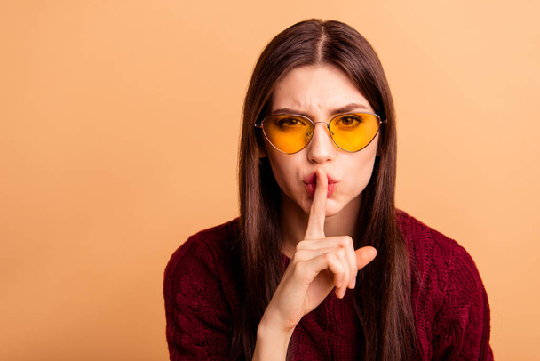 Close up photo beautiful she her lady ask stop tell say speak news listen sound index finger near mouth wear sun specs casual red burgundy knitted pullover sweater isolated pastel beige background - Foto, afbeelding