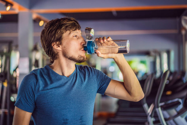 Sport man drinking water in the gym - Photo, image