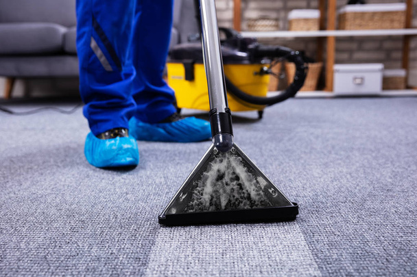 Human Cleaning Carpet In The Living Room Using Vacuum Cleaner At Home - Фото, изображение