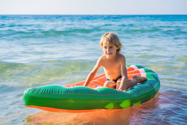 The boy swims in the sea on an inflatable mattress - Foto, Imagem