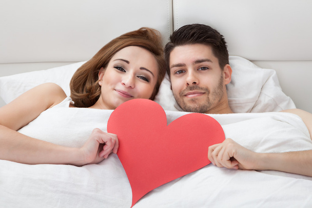 Portrait of young loving couple lying on bed - Valokuva, kuva