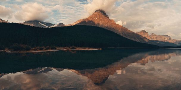 Lake at sunrise with cloud and mountain reflections in Banff National Park - Photo, Image