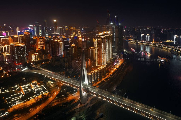 Повітряний вид на міст і міську архітектуру вночі в Чунціні, Китай.. - Фото, зображення