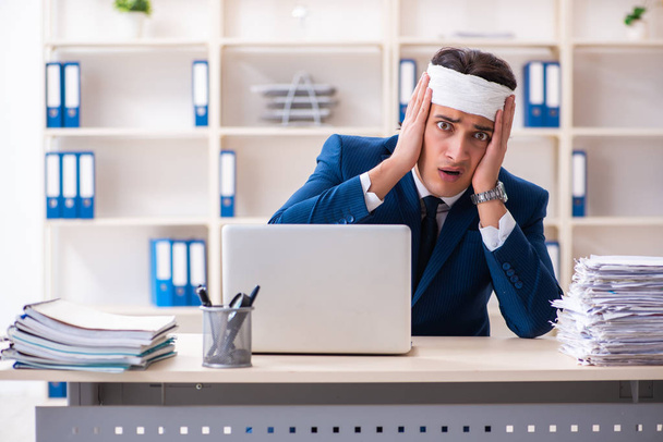 Muž se zraněnou hlavou pracující v kanceláři  - Fotografie, Obrázek