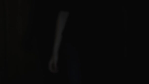 Una mujer con una mano temblorosa sostiene un cuchillo grande de la sombra. De cerca.
.  - Imágenes, Vídeo