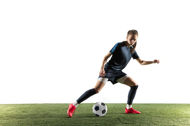 Female soccer player kicking ball isolated over white background - Zdjęcie, obraz