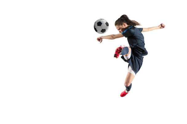 Female soccer player kicking ball isolated over white background - Foto, imagen