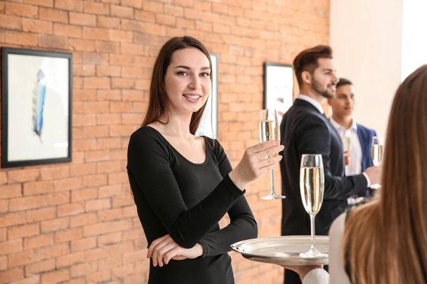 Mujer bebiendo champán en exposición en galería de arte moderno
 - Foto, Imagen