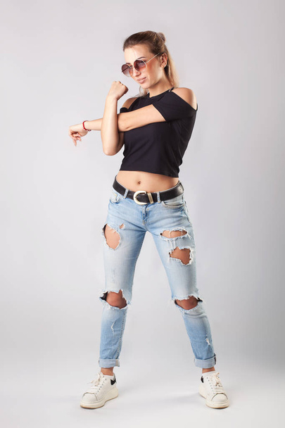 Smiling attractive woman in jeans and T-shirt posing and looking at camera. - Foto, imagen