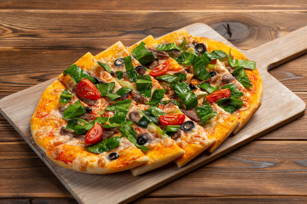 pizza with veal and dried tomatoes on a wooden background - Foto, Imagem