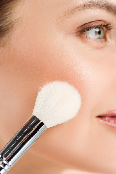 cropped view woman applying blush on cheek with cosmetic brush  - Photo, Image