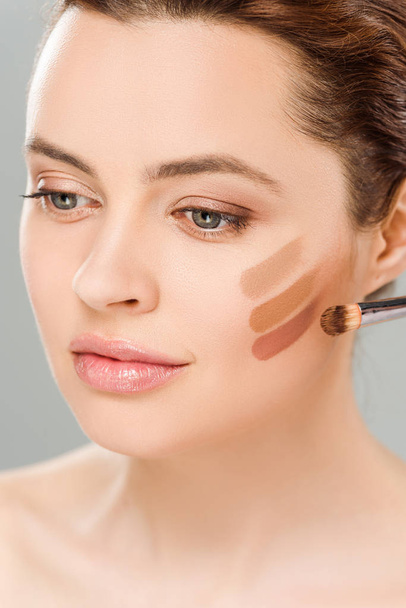 attractive woman with eye shadow brown palette on face isolated on grey - Photo, Image