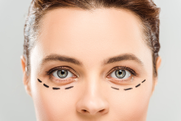 wykadrowany widok kobiety ze znakami na twarzy wyizolowane na szaro  - Zdjęcie, obraz