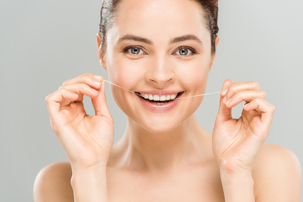 szczęśliwy nagi kobieta zęby Flossing z dentystycznych nici izolowane na szaro  - Zdjęcie, obraz